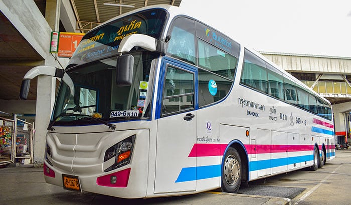 A Sombat Tour company bus parked at Bangkok South Terminal, with distinctive blue and purple stripes, running between Phuket and Bangkok.